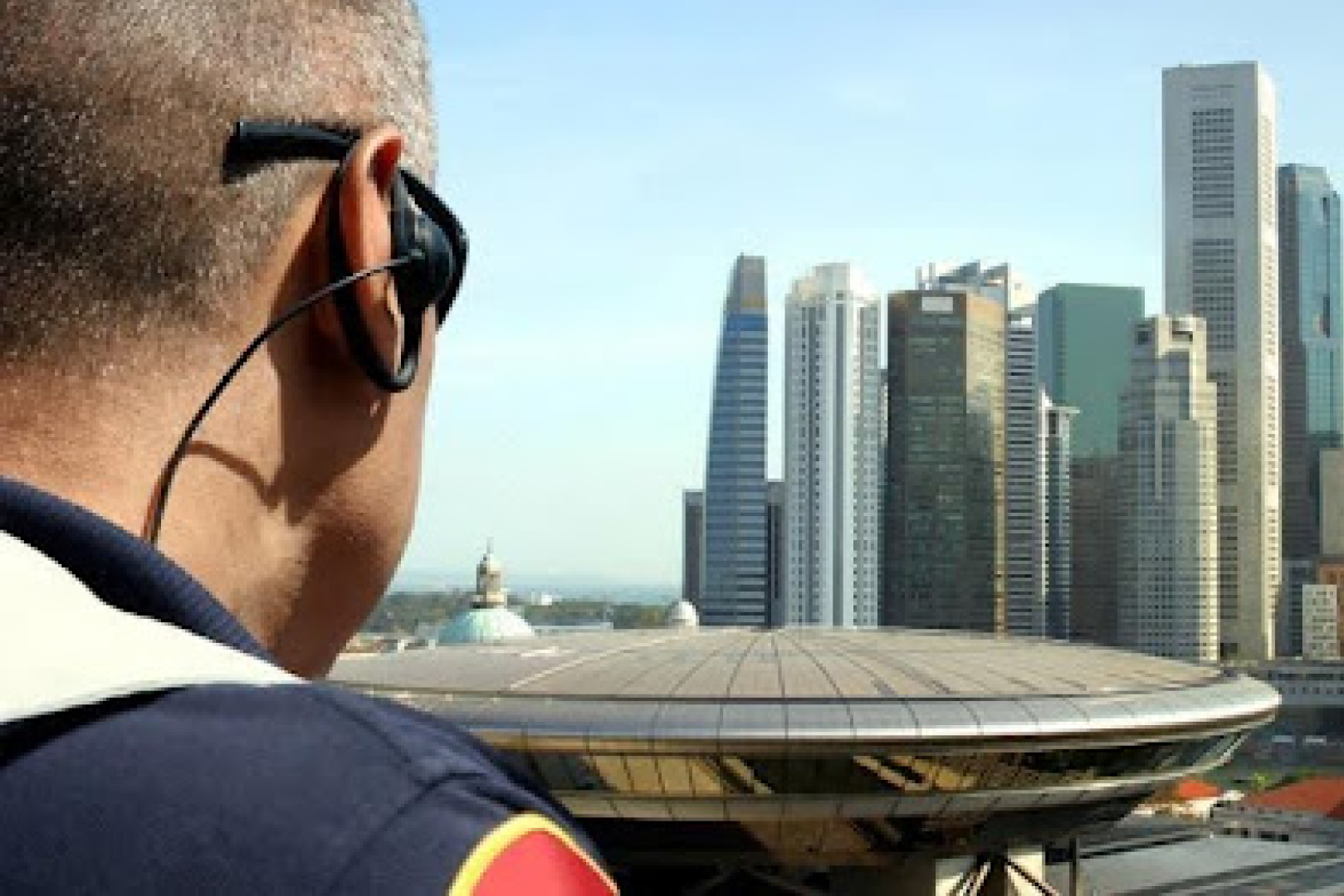 A man with headphones looking out over the city.