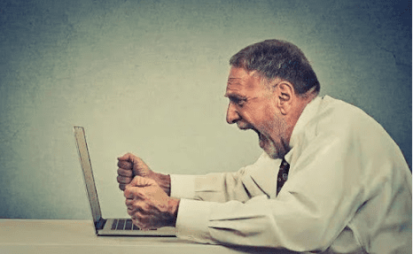A man sitting at a table with his laptop.
