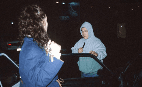 A man in a blue jacket is holding a knife
