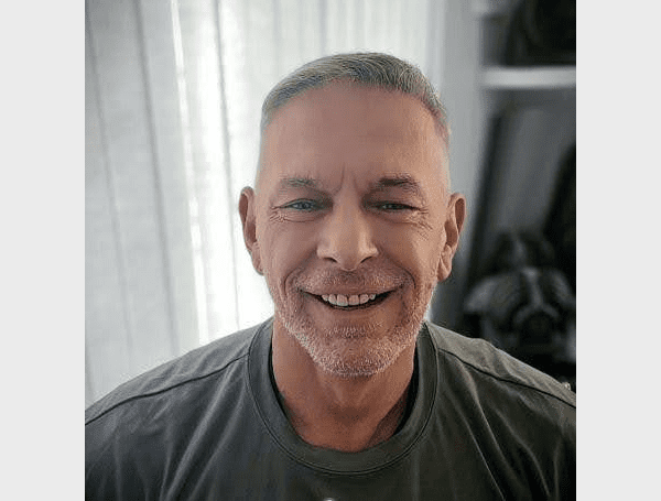 A man with gray hair smiling for the camera.
